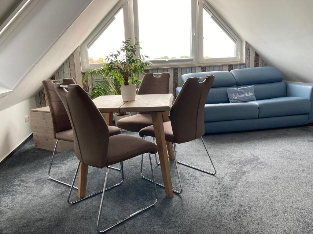 a table and chairs in a living room with a couch at Meerblick 14 in Grömitz