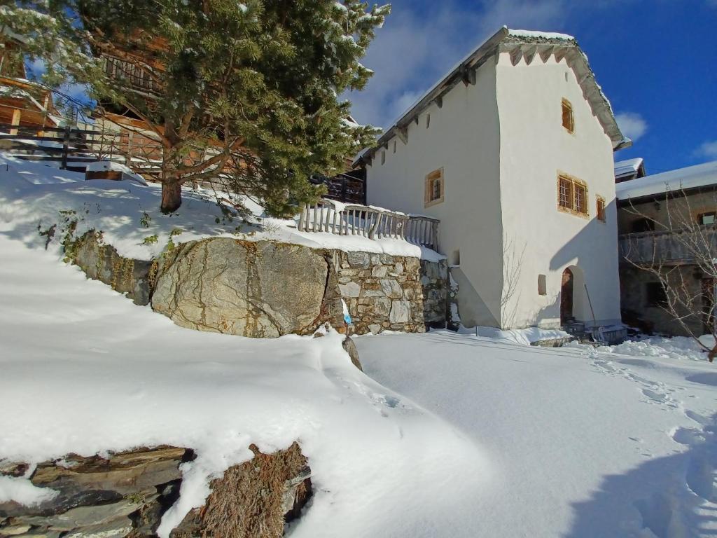 uma casa com neve em frente em Ferienhaus Turilji em Albinen