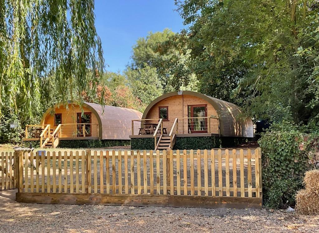 two yurt homes are behind a wooden fence at Outdoor Inns - Star at Lidgate in Newmarket