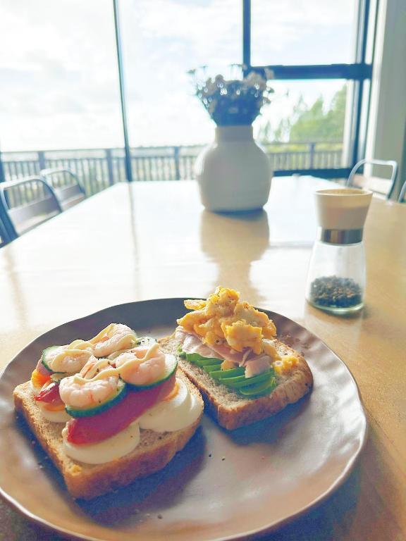 a plate with two pieces of toast with shrimp on it at Echo Lodge in Auckland