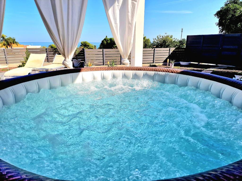 a large hot tub in a backyard with blue water at Villa Nico in Casteldaccia