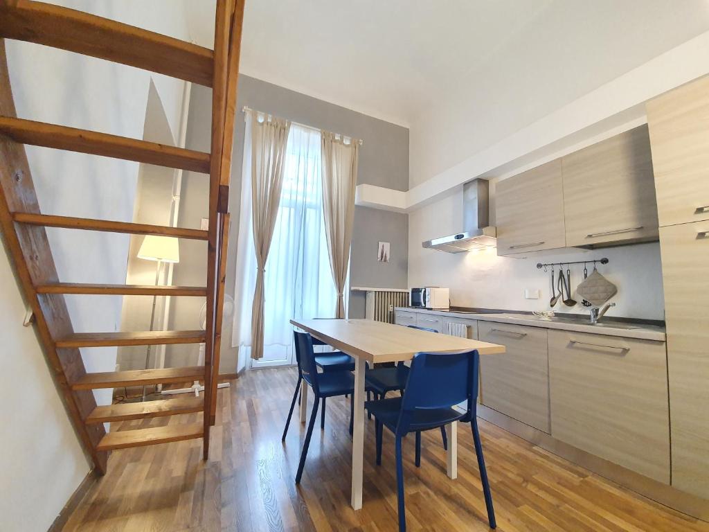 uma cozinha com mesa e cadeiras num quarto em Casa Marsili - Luxury Apartment em Turim