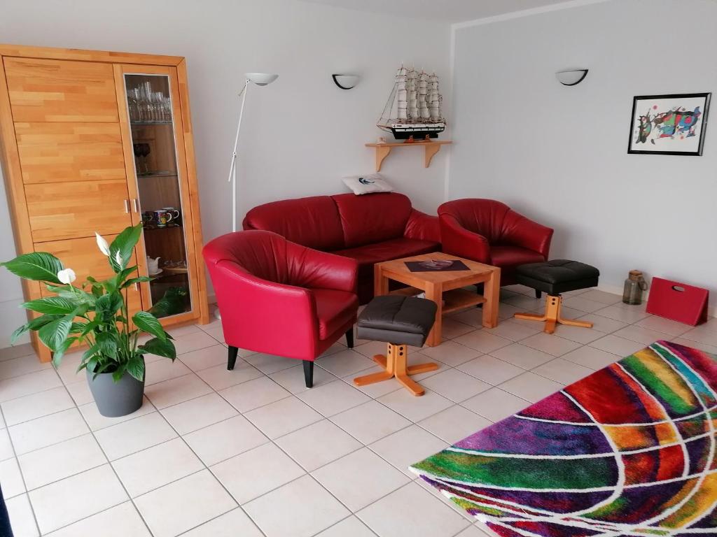 ein Wohnzimmer mit einem roten Sofa und einem Tisch in der Unterkunft Ferienwohnung Andresen in Rerik