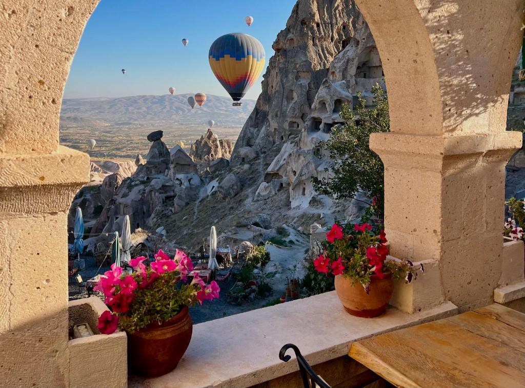 uma varanda com vista para um balão de ar quente em Duven Hotel Cappadocia em Üçhisar