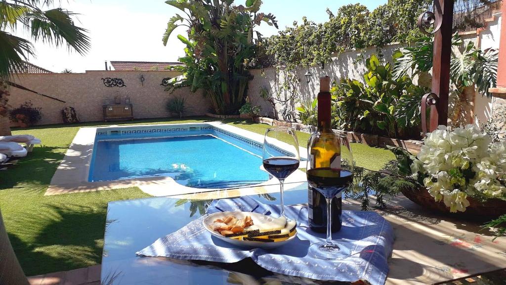een tafel met een fles wijn en een kom eten bij LOS CLAVELES in Hornachuelos