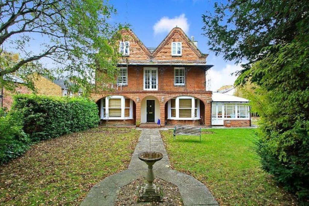 uma grande casa de tijolos com um jardim em frente em Flat 2, 158 Abingdon Road em Oxford