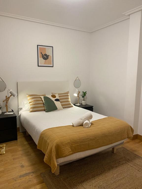 1 dormitorio con 1 cama grande y 2 lámparas en Apartamento Amplio y Central a pie de Playa la Concha, en San Sebastián