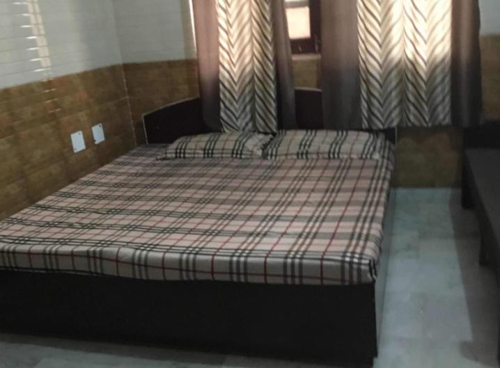 a bedroom with a bed with a plaid mattress at Hotel Vijay by WB Inn in Kānpur