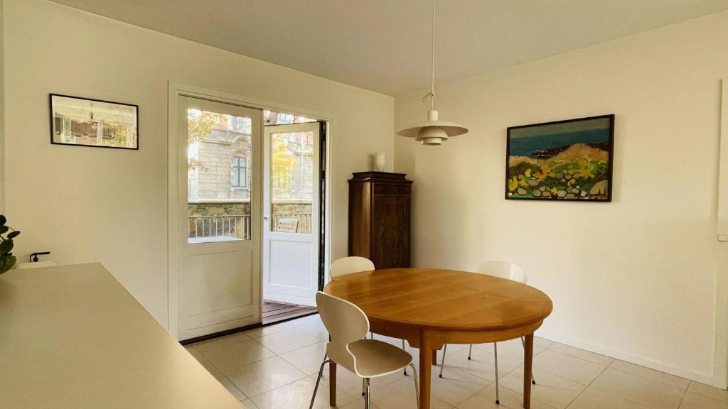 jadalnia z drewnianym stołem i krzesłami w obiekcie ApartmentInCopenhagen Apartment 1517 w Kopenhadze
