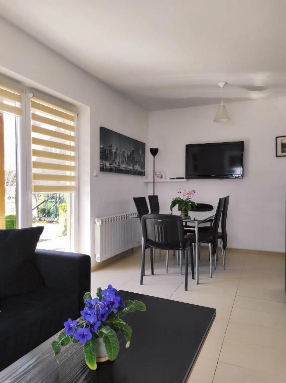 een woonkamer met een zwarte bank en een tafel bij Sielski Domek pod Karpaczem in Miłków