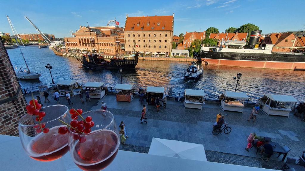 a view of a river with some wine glasses at Downtown Apartments Magical River View in Gdańsk