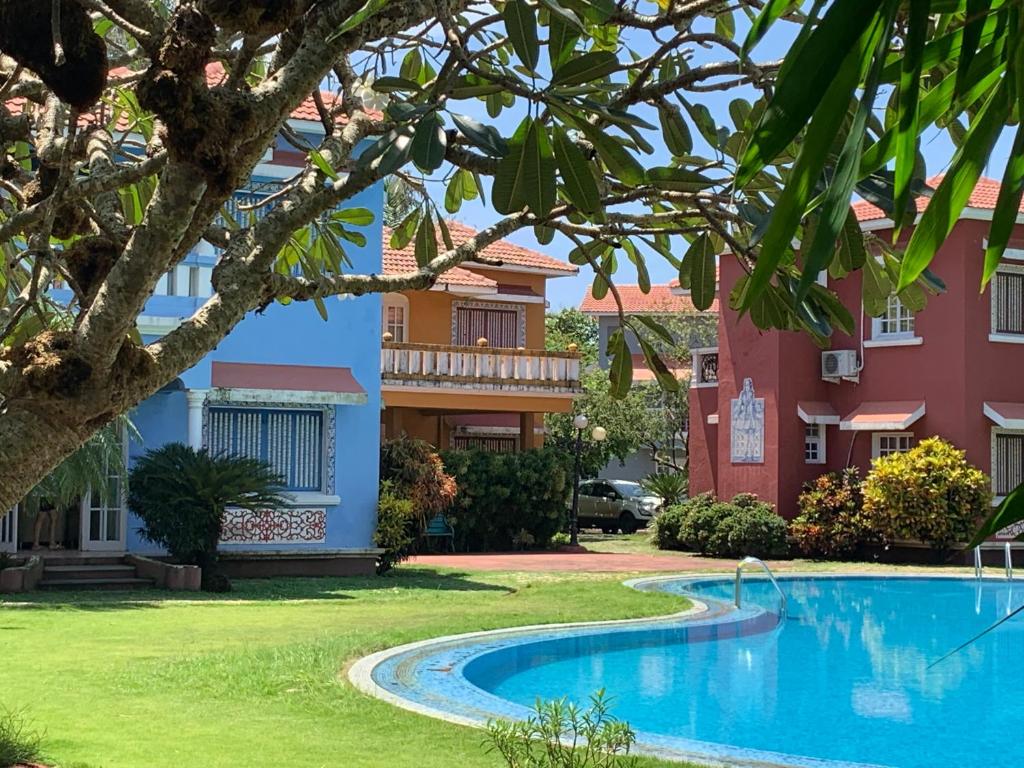 un complejo con piscina frente a un edificio en Villa Marina By The Beach Goa en Benaulim