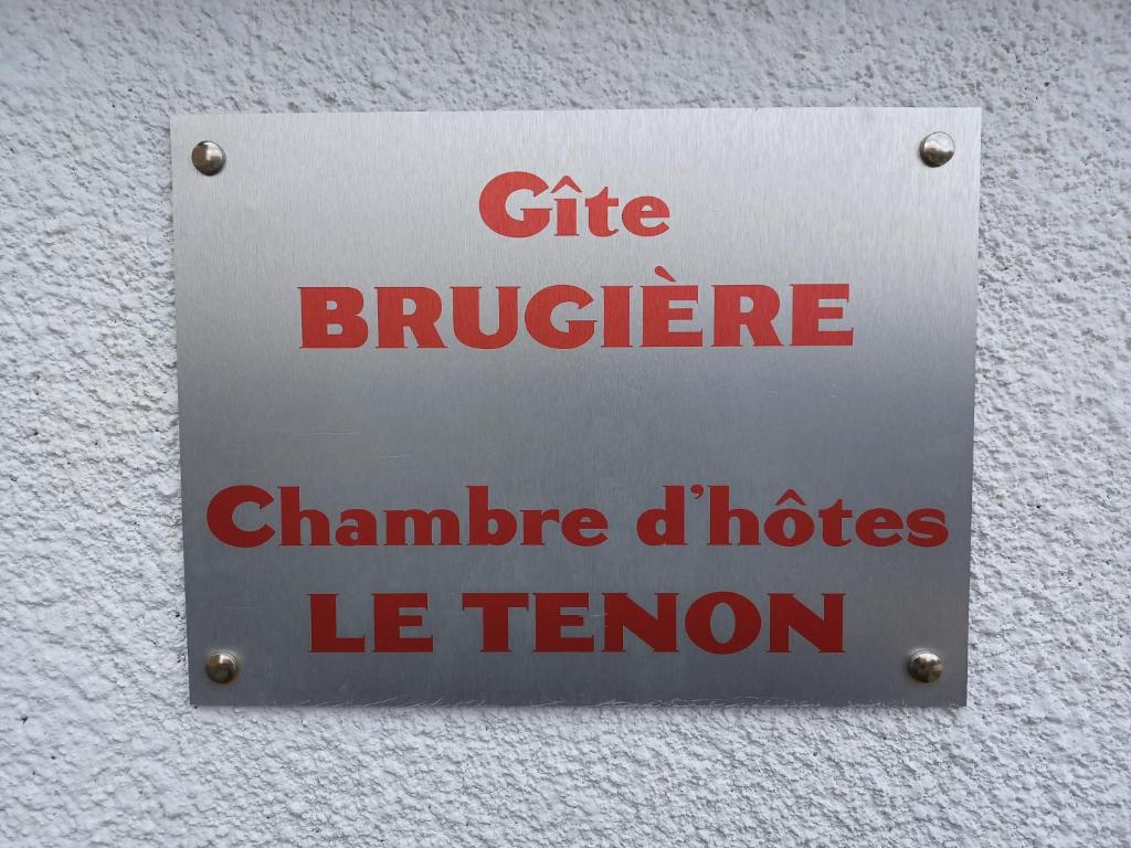 una señal en el lateral de un edificio con escritura roja en Maison avec 2 chambres est un Gîte Brugière et maison une chambre est une chambre d'hôtes, en Murat-le-Quaire