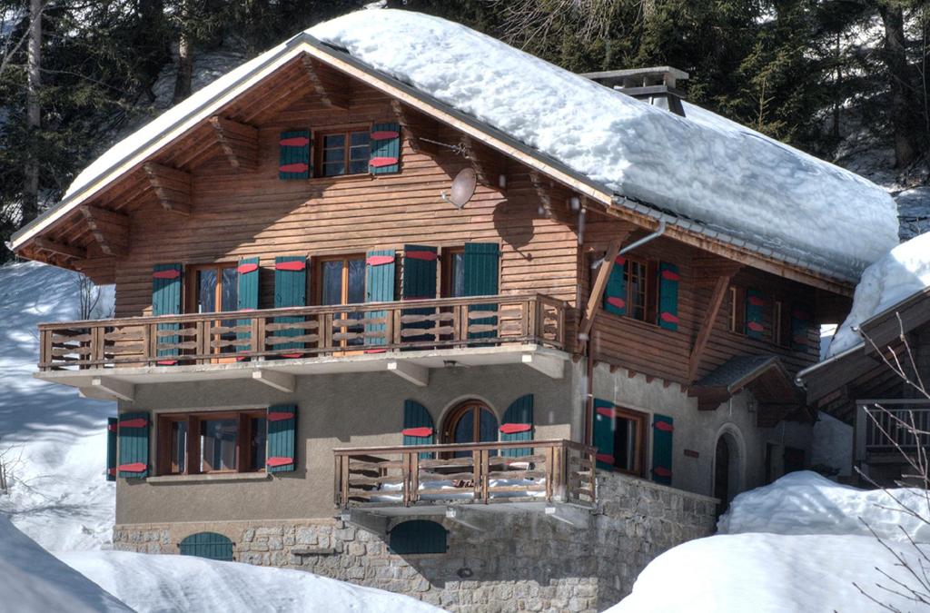 una baita di tronchi con neve sul tetto di La Ribambelle a Chamonix-Mont-Blanc