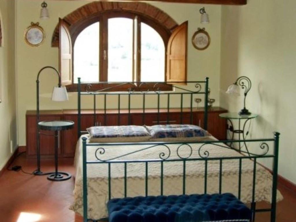 una camera con letto in metallo e finestra di Charming apartment in Poppi with shared garden a Poppi