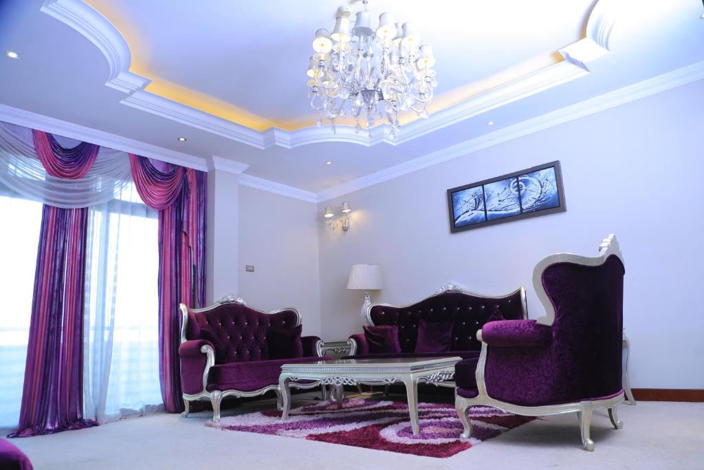 a living room with purple furniture and a chandelier at Sidra International Hotel in Addis Ababa