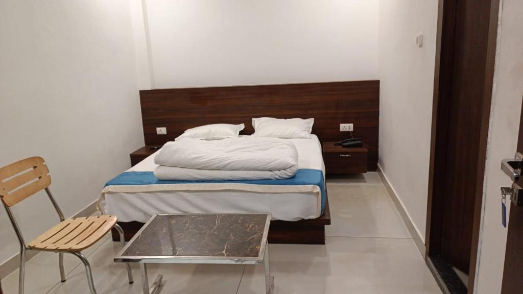 1 dormitorio pequeño con 1 cama y 1 silla en Hotel Cross Road By WB Inn en Unnāo