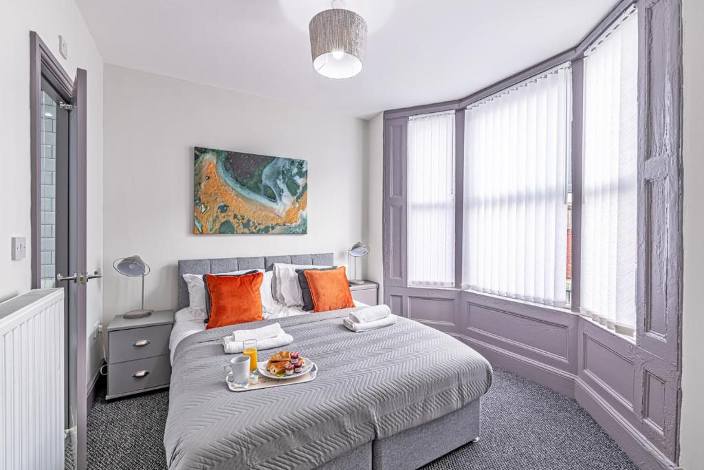 a bedroom with a bed with a tray of food on it at 3 Bedroom Holiday Home Liverpool in Liverpool