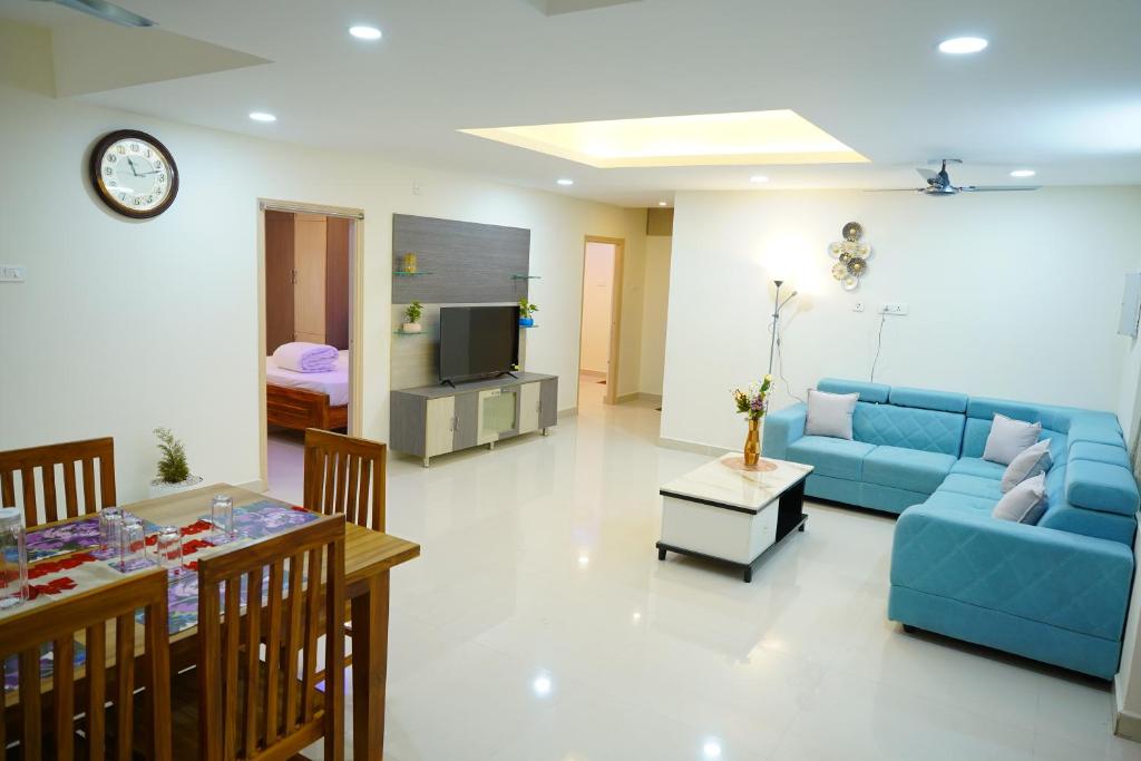 - un salon avec un canapé bleu et une table dans l'établissement Priya Woodz Homestay, Tirupati, à Tirupati