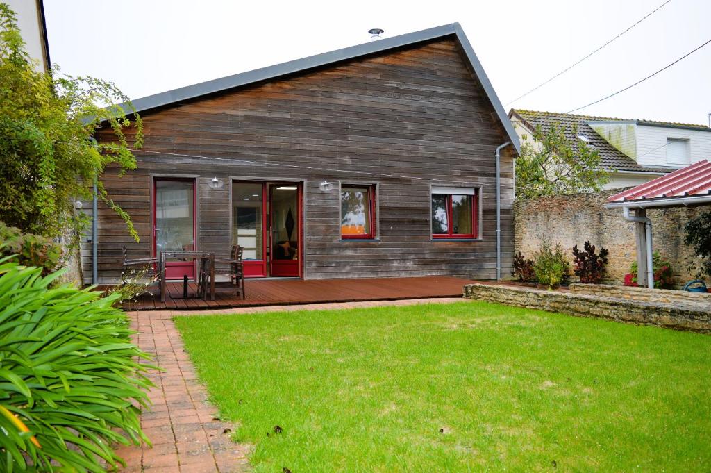 Cette maison dispose d'une terrasse et d'une pelouse. dans l'établissement Le Break - maison de plain-pied avec jardin, à Courseulles-sur-Mer