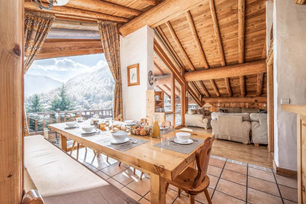 una sala da pranzo con tavolo e vista di Madame Vacances Chalet La Grande Sassière a Val dʼIsère