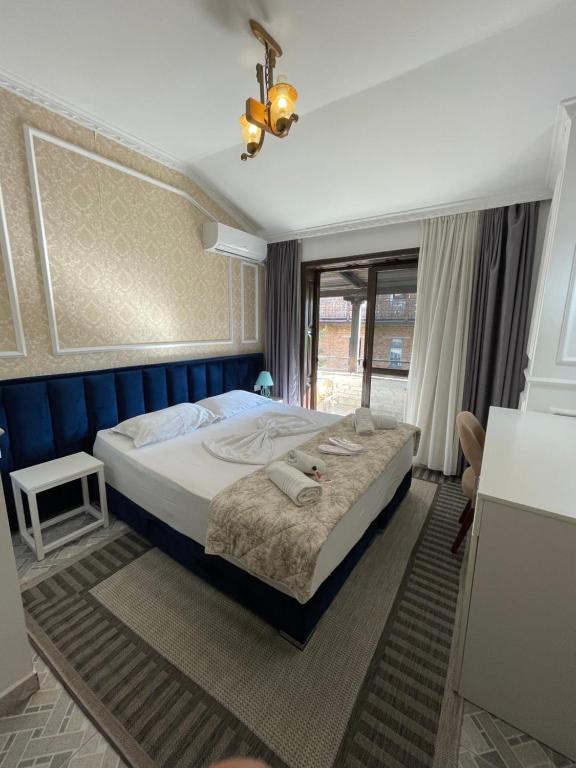 een slaapkamer met een groot bed met een blauw hoofdeinde bij VILA SANREMO in Tirana