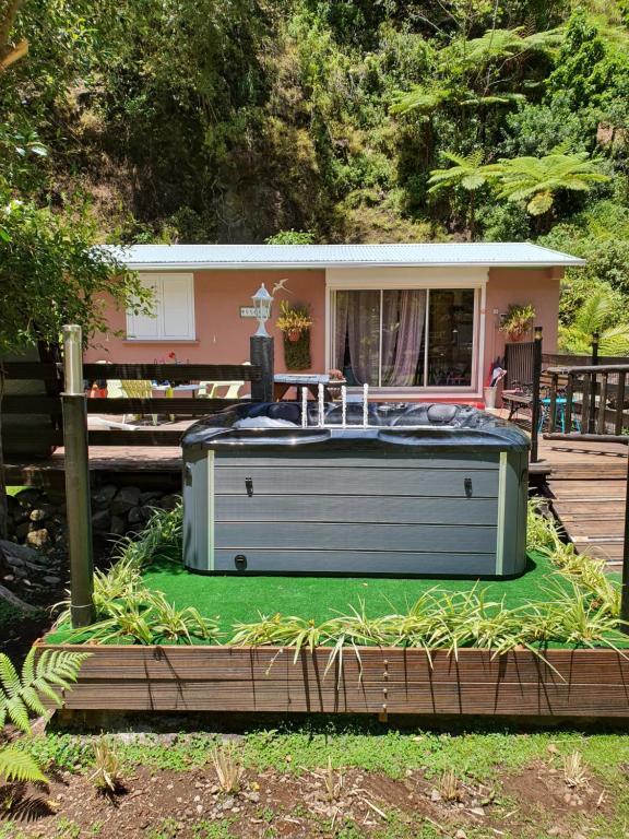 un bain à remous sur une pelouse en face d'une maison dans l'établissement Gite LA CASCADE BLANCHE, à Salazie