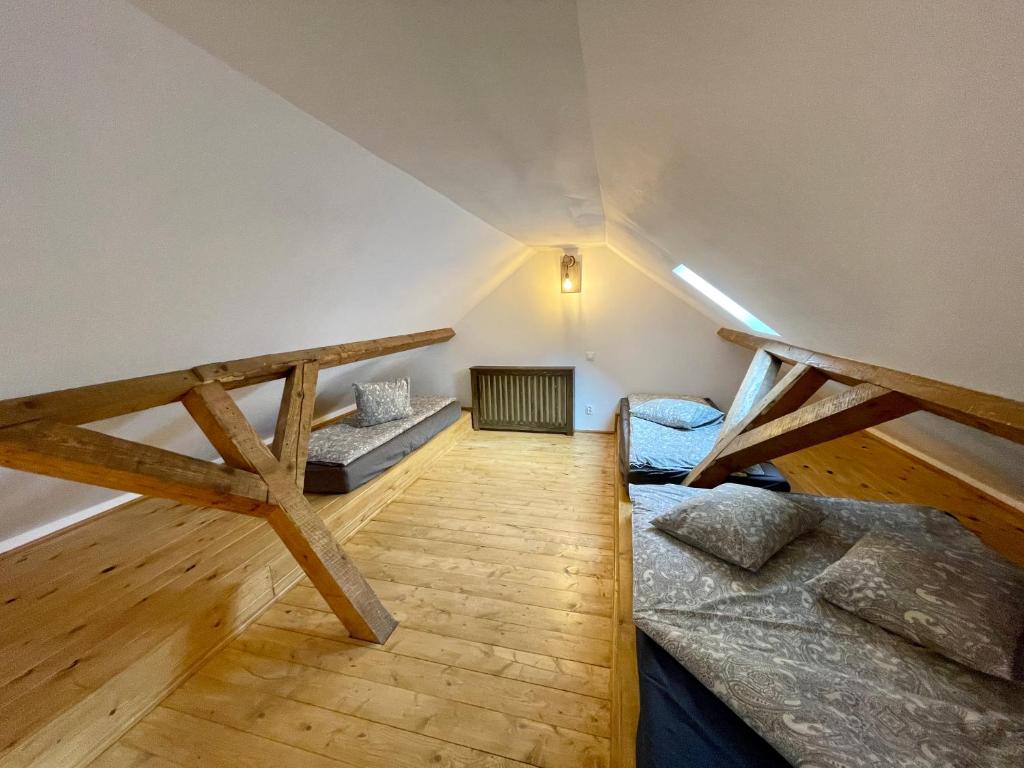 a attic room with two bunk beds and a ladder at Zengő in Miercurea-Ciuc
