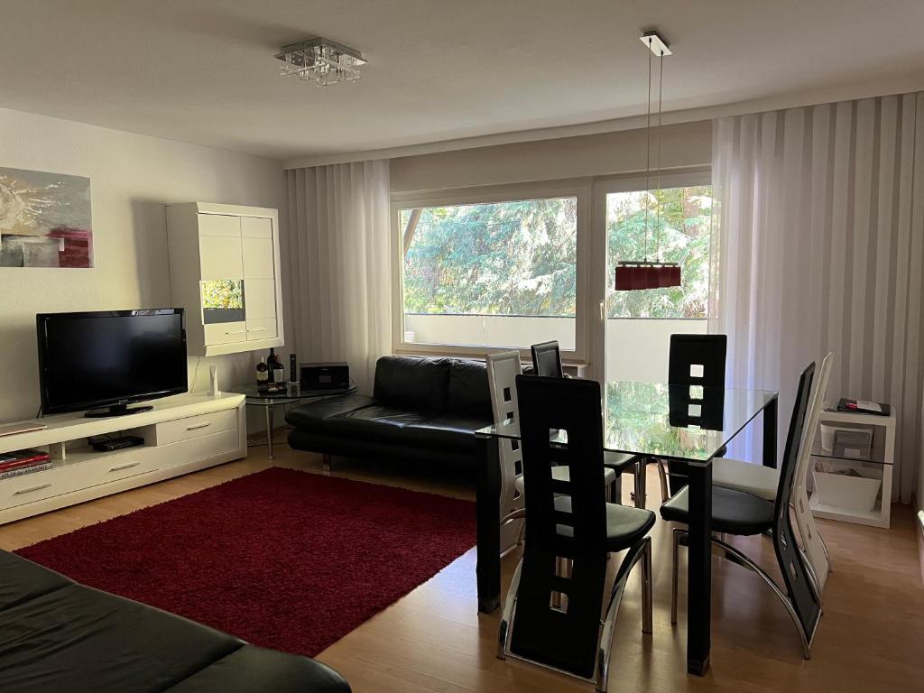 a living room with a couch and a table and a television at Deluxe Apartment Baden-Baden in Baden-Baden