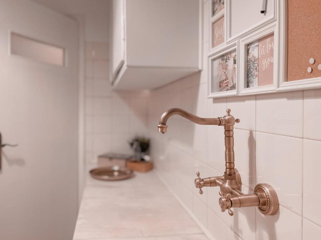 łazienka z miedzianym kranem na ścianie w obiekcie Boho Chic 2BR Apartment in the Center of Athens w Atenach