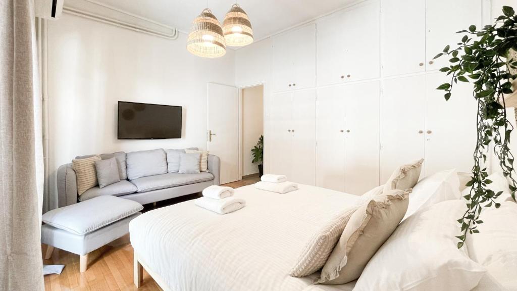 biały pokój z dwoma łóżkami i kanapą w obiekcie Boho Chic 2BR Apartment in the Center of Athens w Atenach