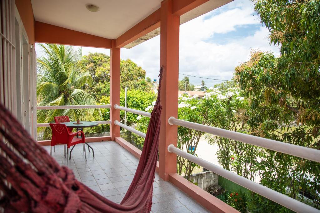 a hammock on a balcony with a table and chairs at Serrambi Praia Suites in Porto De Galinhas