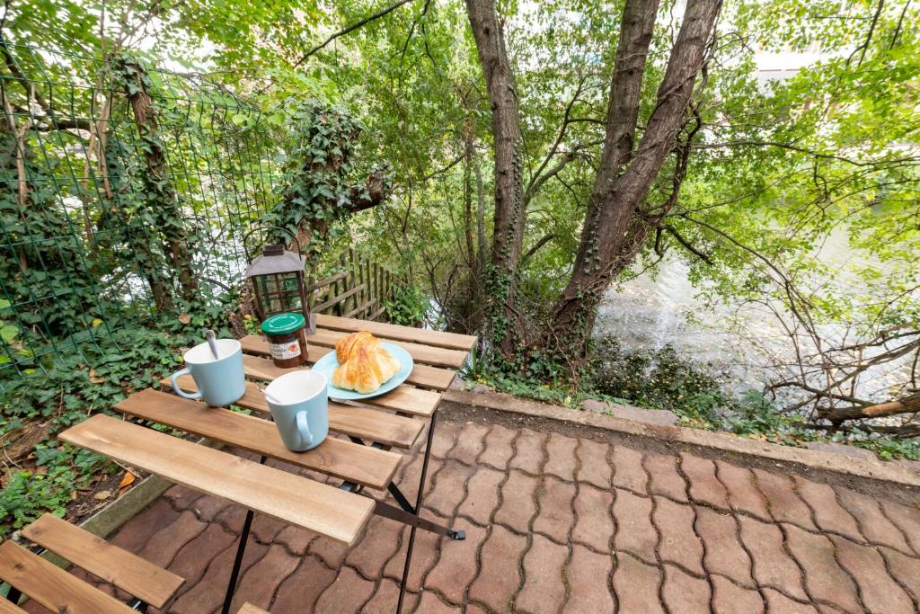 uma mesa de piquenique de madeira com um prato de comida em Terrasse des Loges em Rennes