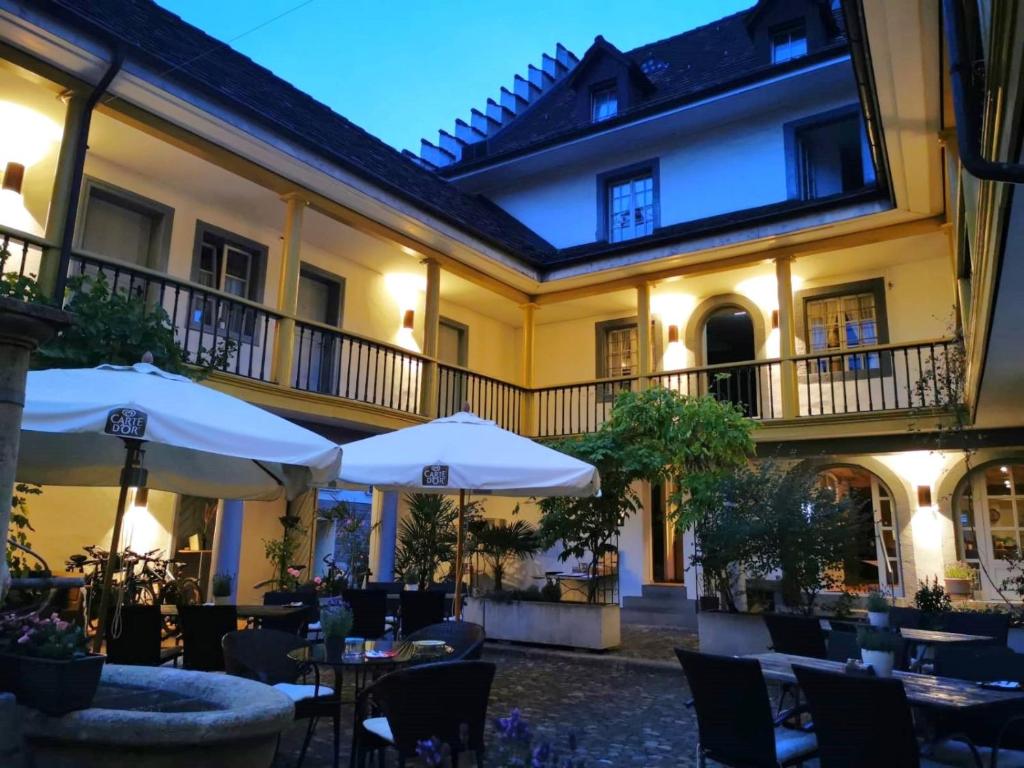 ein Restaurant mit Tischen und Sonnenschirmen im Innenhof in der Unterkunft Gasthof zur Waag in Bad Zurzach