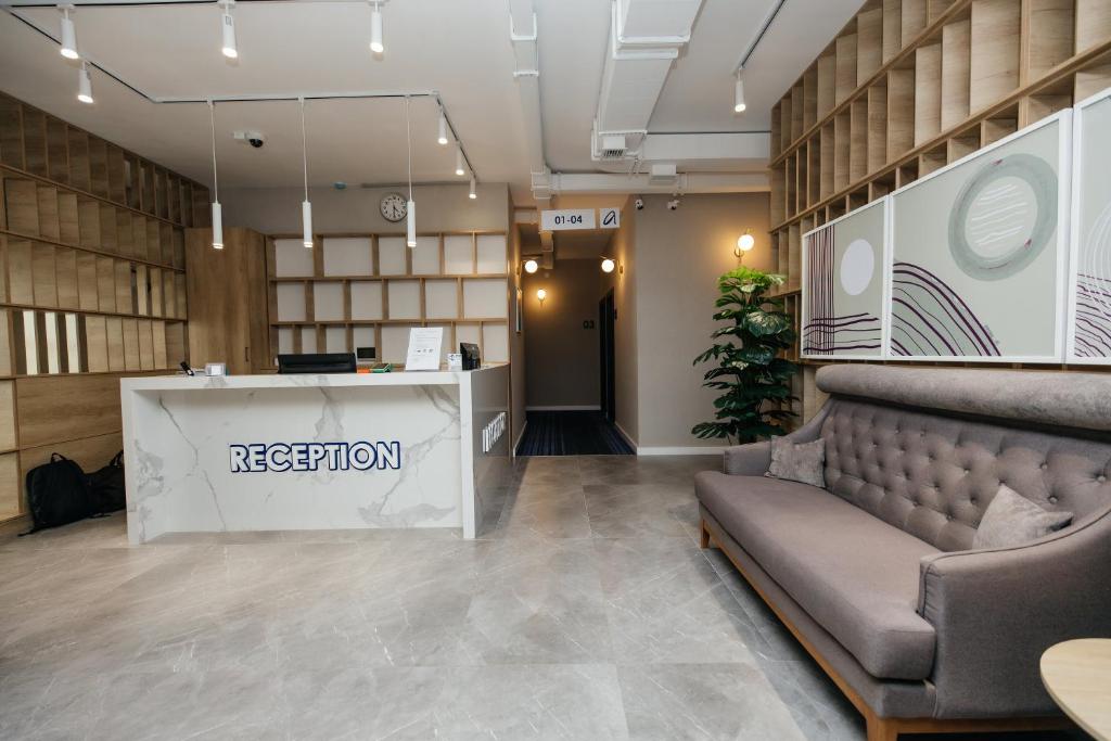 a reception room with a couch and a reception desk at AMINA HOTEL in Astana