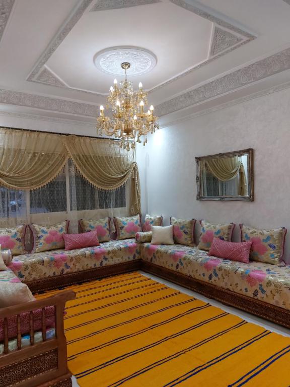ein Wohnzimmer mit einem Sofa und einem Kronleuchter in der Unterkunft Majorelle appartement in Fès