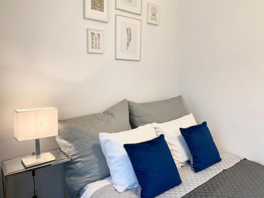 1 dormitorio con 1 cama con almohadas azules y blancas en Ultra Apartments Kamienica Nova II en Szczecin