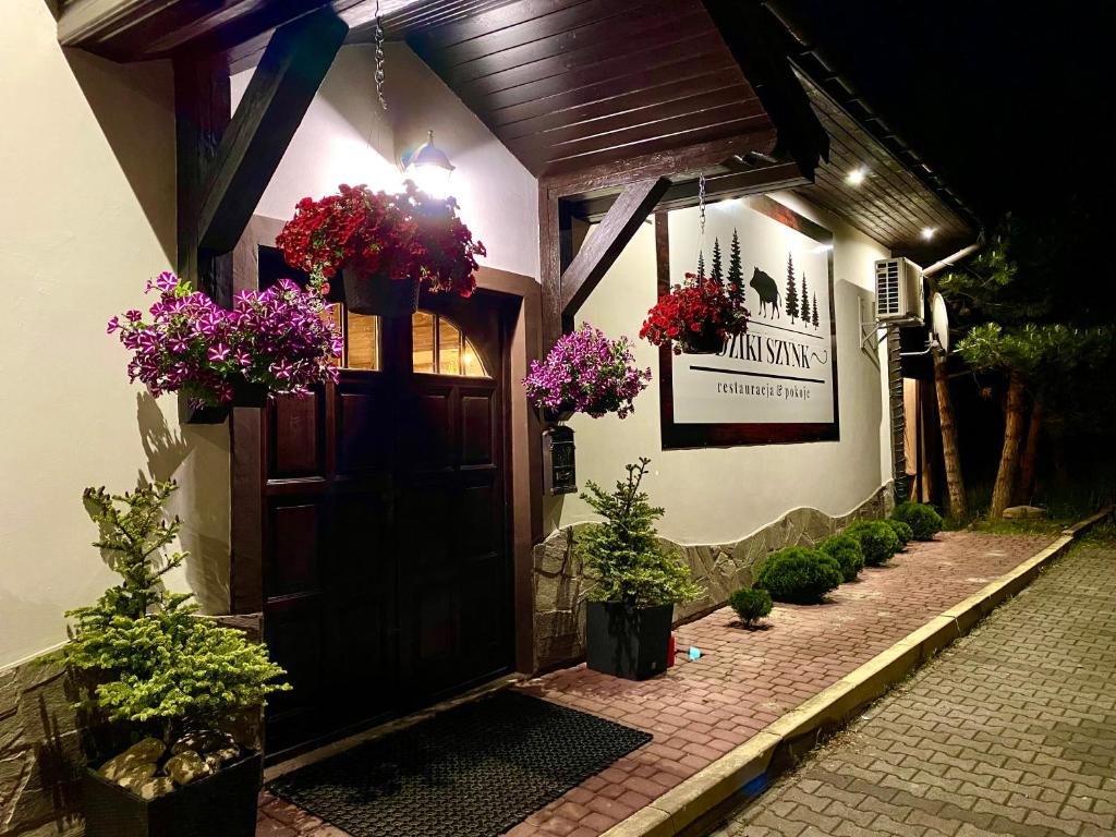 a building with a door with flowers on it at Dziki Szynk in Brenna