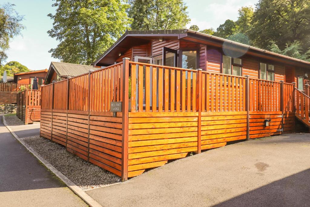 a wooden house with a fence in front of it at Fell Foot Lodge in Windermere