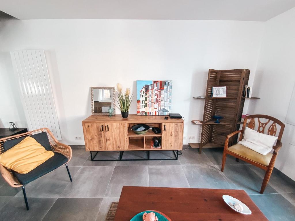 a living room with two chairs and a wooden cabinet at Gritxu Etxea in Biarritz