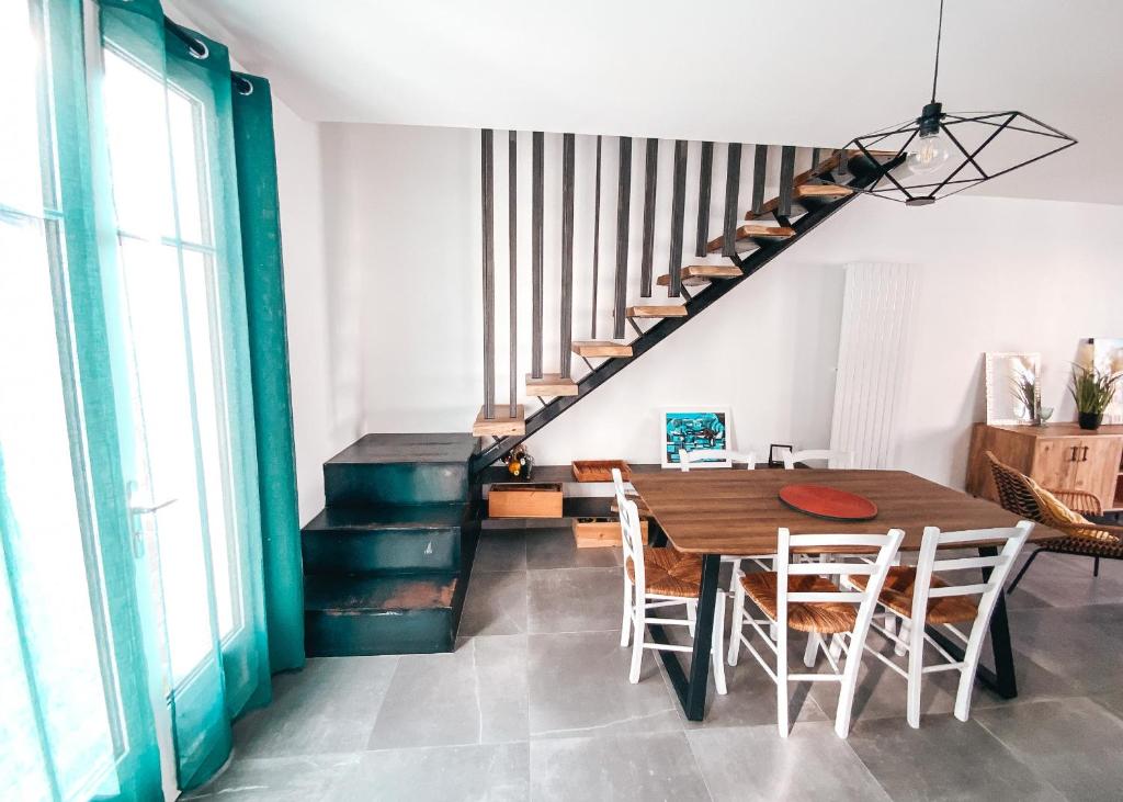 a dining room with a table and chairs and a staircase at Gritxu Etxea in Biarritz