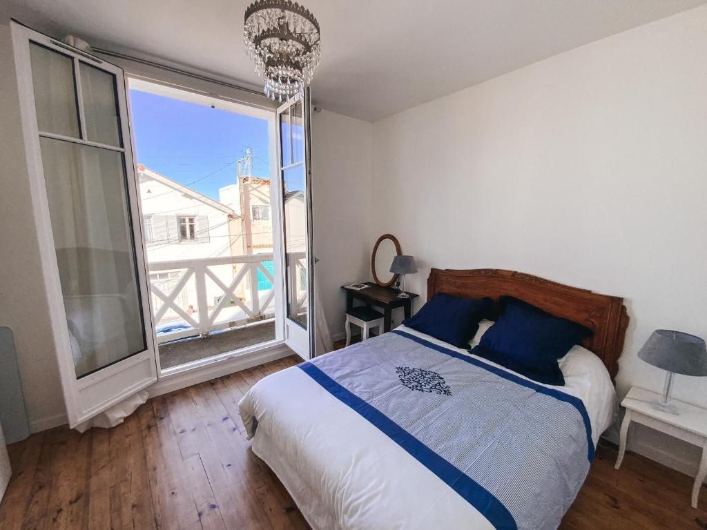 a bedroom with a bed and a large window at Gritxu Etxea in Biarritz