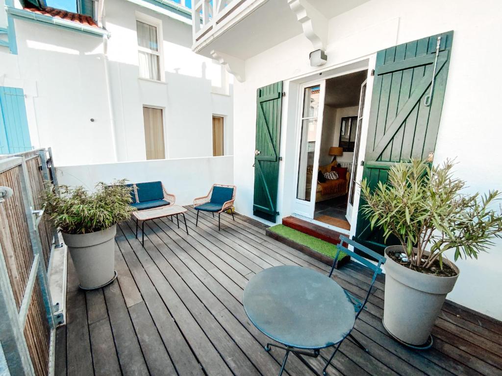 a patio with chairs and a table on a deck at Gritxu Etxea in Biarritz