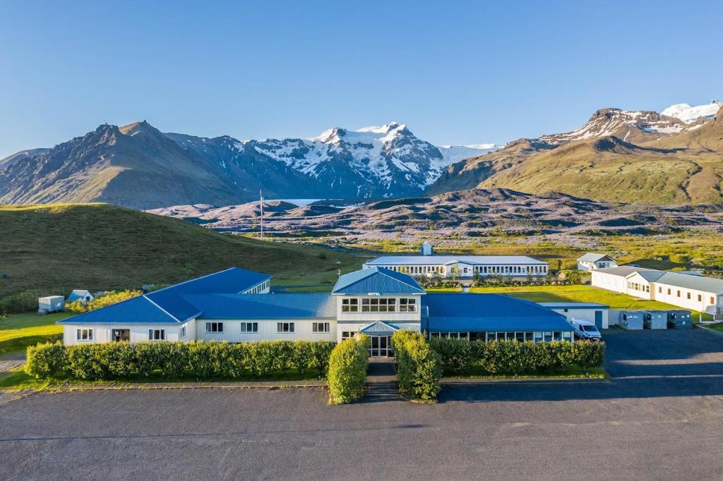 une vue aérienne sur un bâtiment avec des montagnes en arrière-plan dans l'établissement Hotel Skaftafell, à Skaftafell