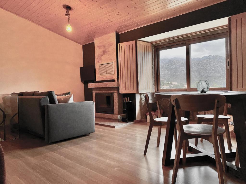 a living room with a couch and a table with chairs at Green Man Gerês Mountain House in Campo do Gerês