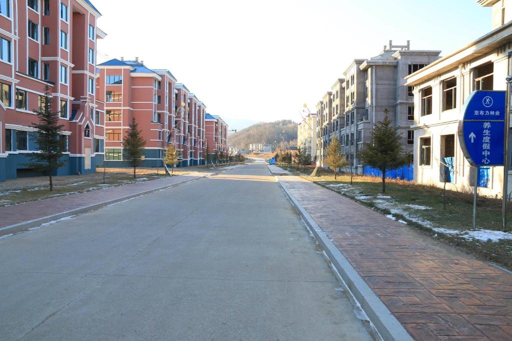 an empty street in a city with buildings at Yabuli Hot Spring Health Center Hotel in Shangzhi