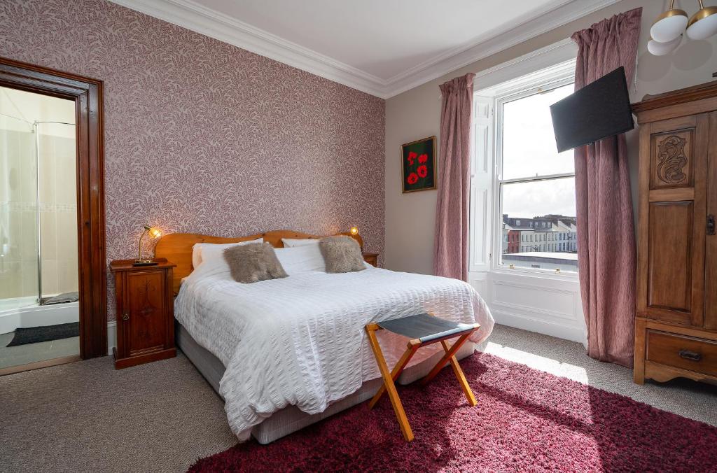 a bedroom with a bed and a window at Antrim House Guest Rooms & Suites in Portrush