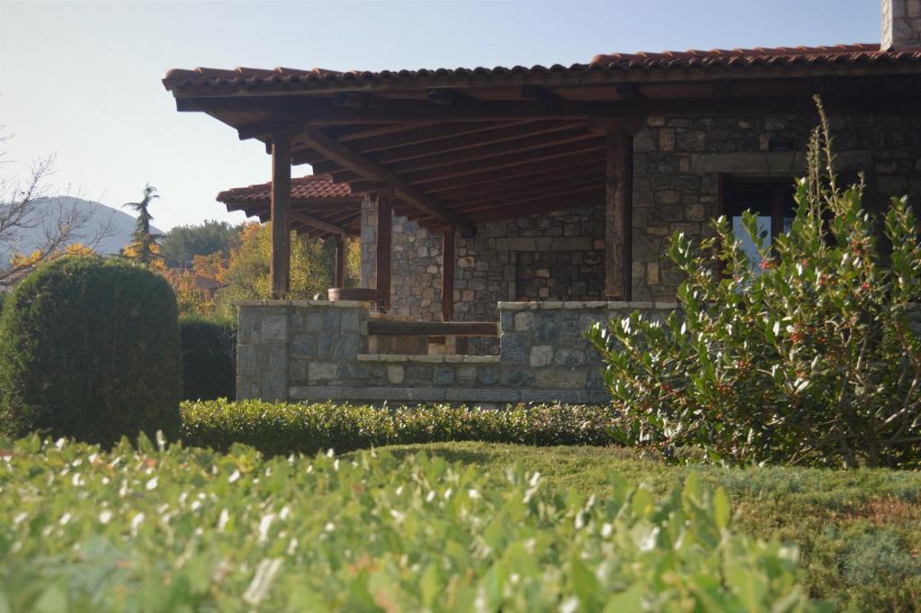 a stone house with a wooden roof at Happy trails Guesthouse Vitina in Vitina