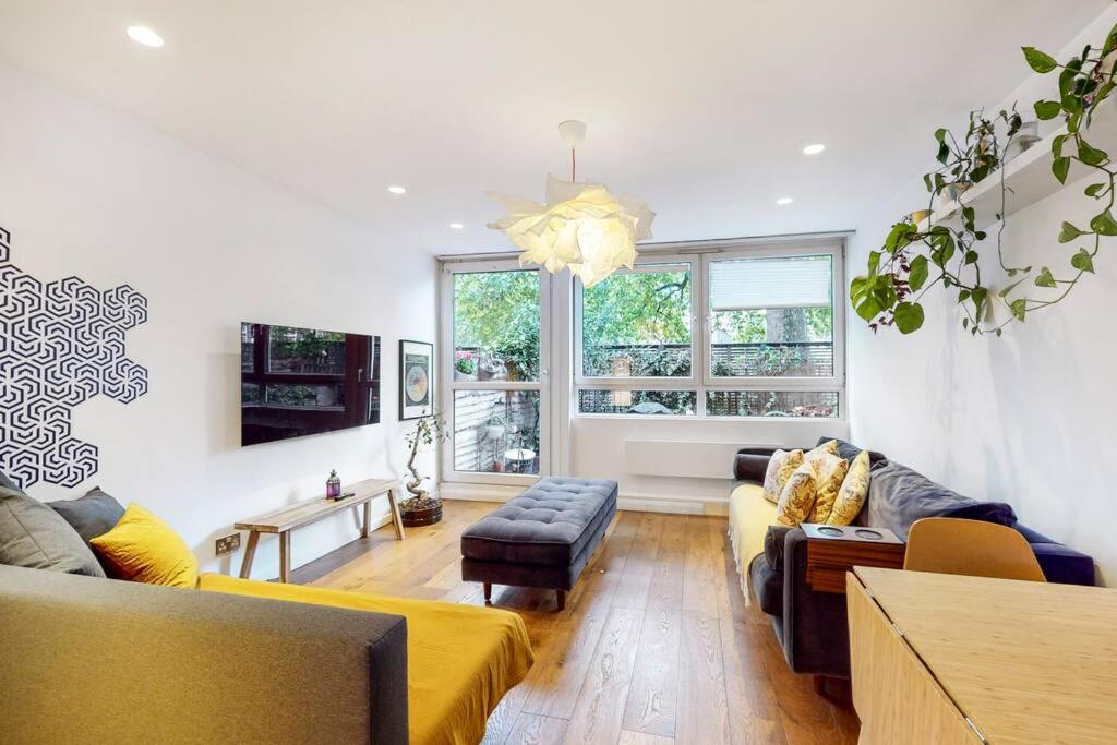 una sala de estar con 2 sofás y una ventana grande en Charming 2-bedroom maisonette with private garden, en Londres