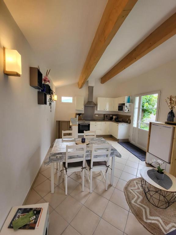 kuchnia i jadalnia ze stołem i krzesłami w obiekcie Nid douillet - LES FARGETTES - superbe vue - charmante petite maison avec jardin - 2 pièces à Privas w mieście Privas